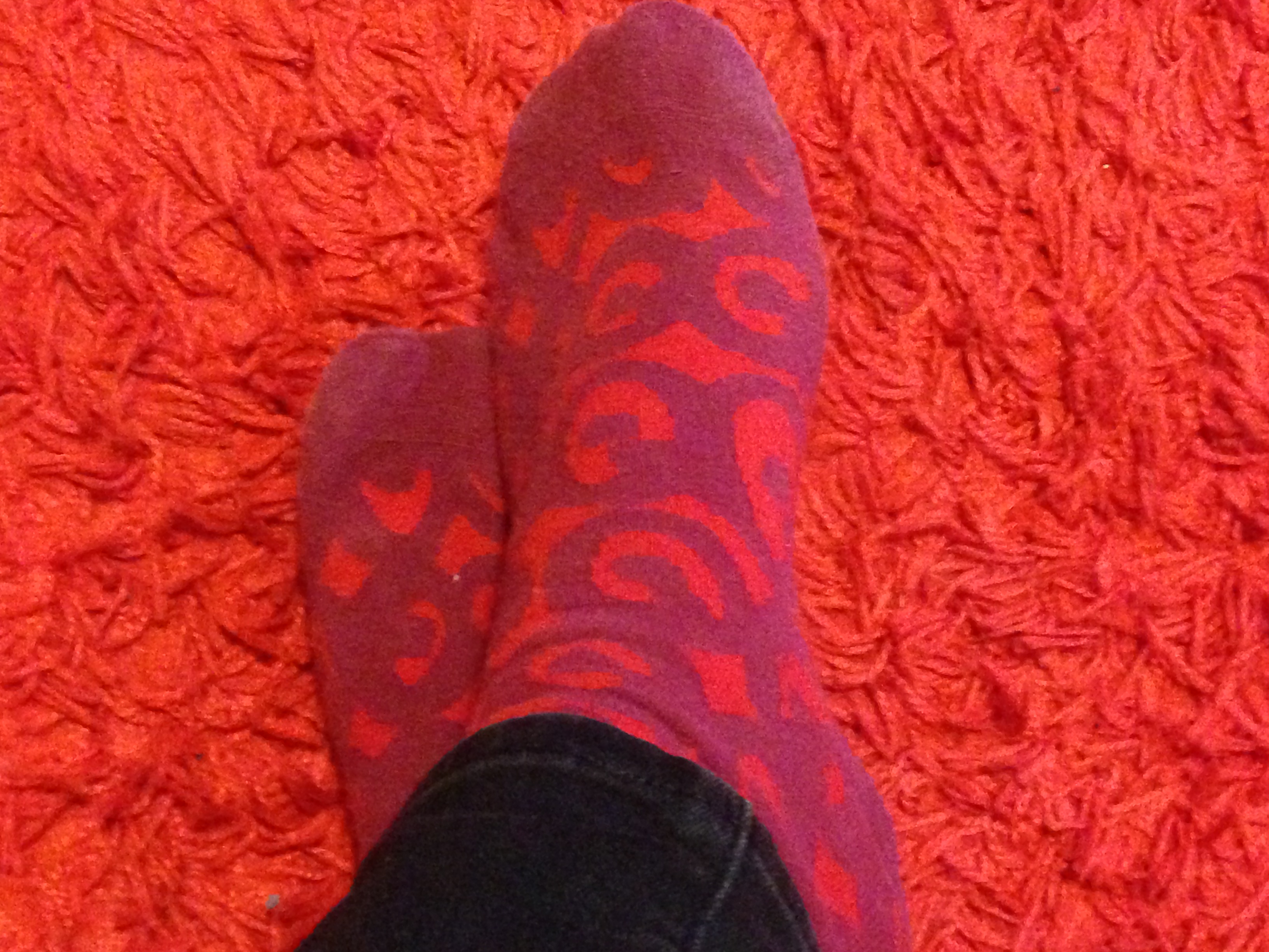 bright red and purple marimekko socks on a bright red shag rug